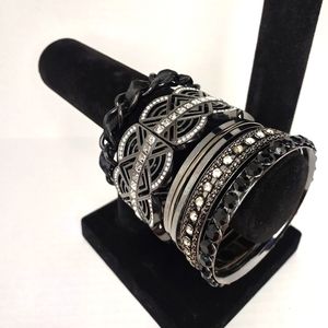 Stack of silver and black bracelets